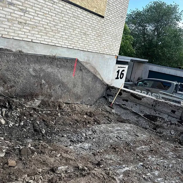 Utgravd tomt ved murhus med nummer 16, klart for grunnarbeid.