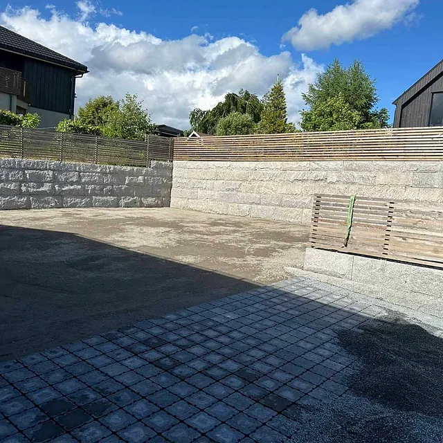 Ferdig uteområde med mur, grus og nylagt belegningsstein.